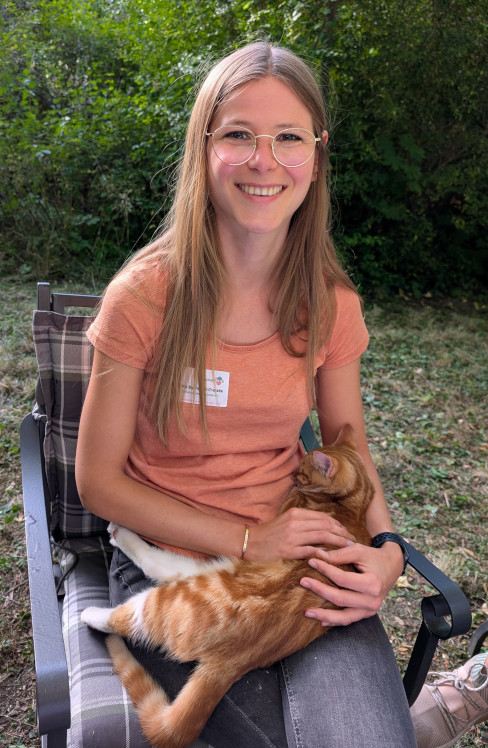 Katze liegt bei Gina vom FOERBICO-Team im Schoß und schläft.