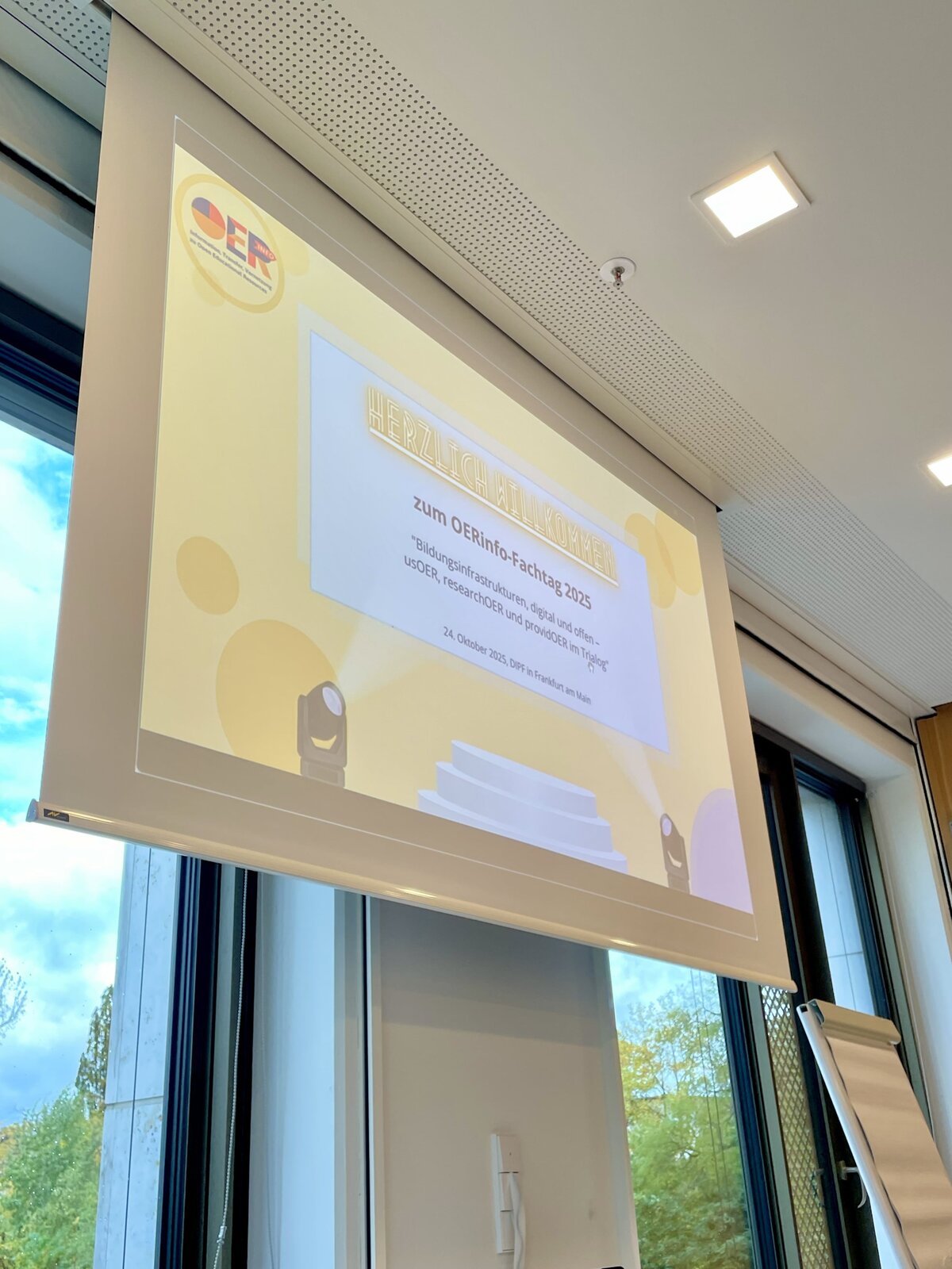 Präsentationsfolie mit Aufschrift &ldquo;Herzlich willkommen zum OERinfo-Fachtag 2025. Bildungsinfrastrukturen, digital und offen - usOER, researchOER und providOER im Trialog&rdquo; am 24. Oktober 2025 im DIPF Frankfurt am Main.