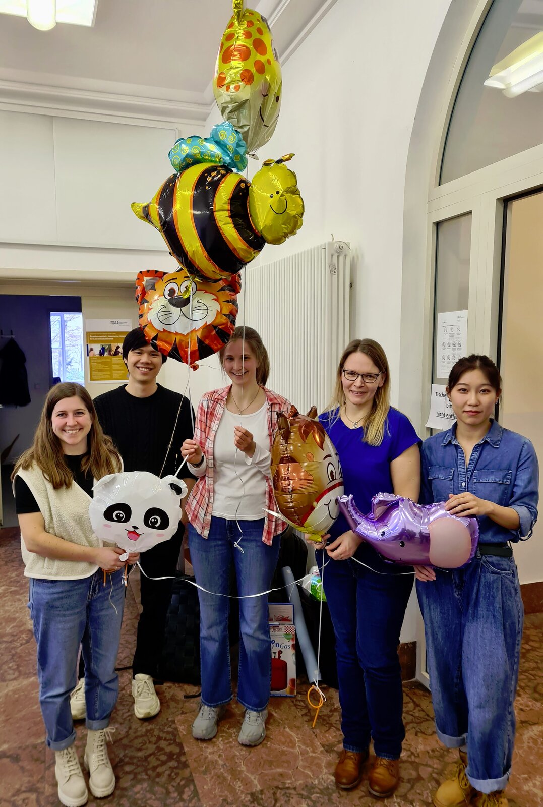 Team der Hilfskräfte der Zwischenfazit-Tagung mit Tier-Luftballons.